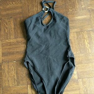 Black one piece swimsuit with metal ring at neck.